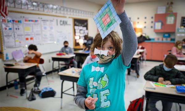 Boy holds up paper kite